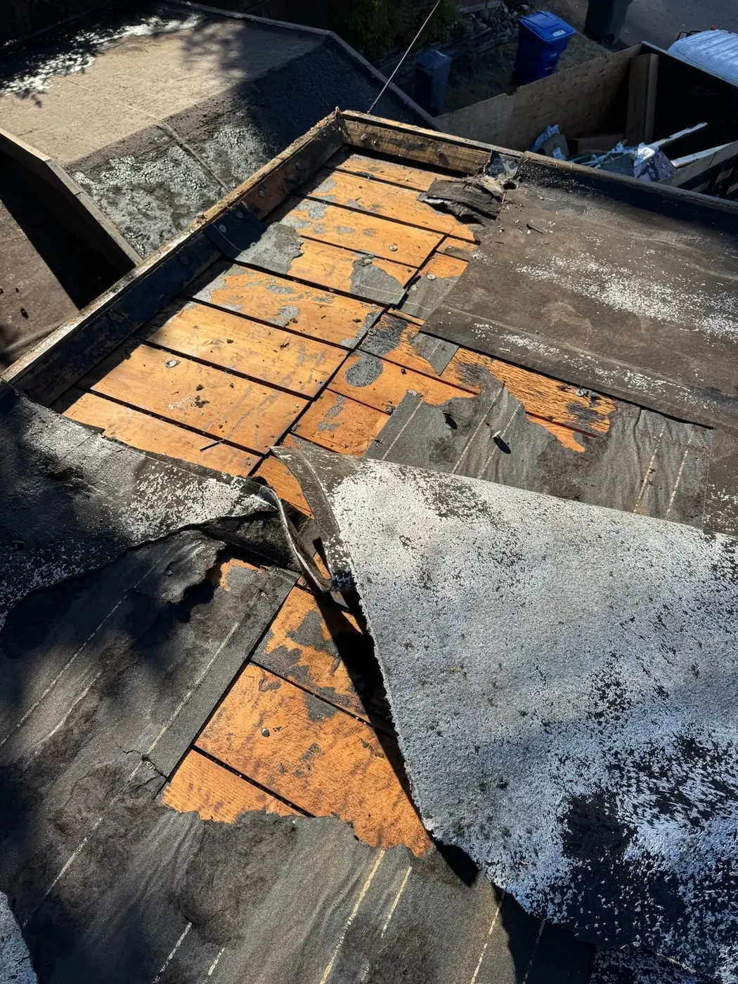 Torn and patched failed membrane on a flat roof before replacement
